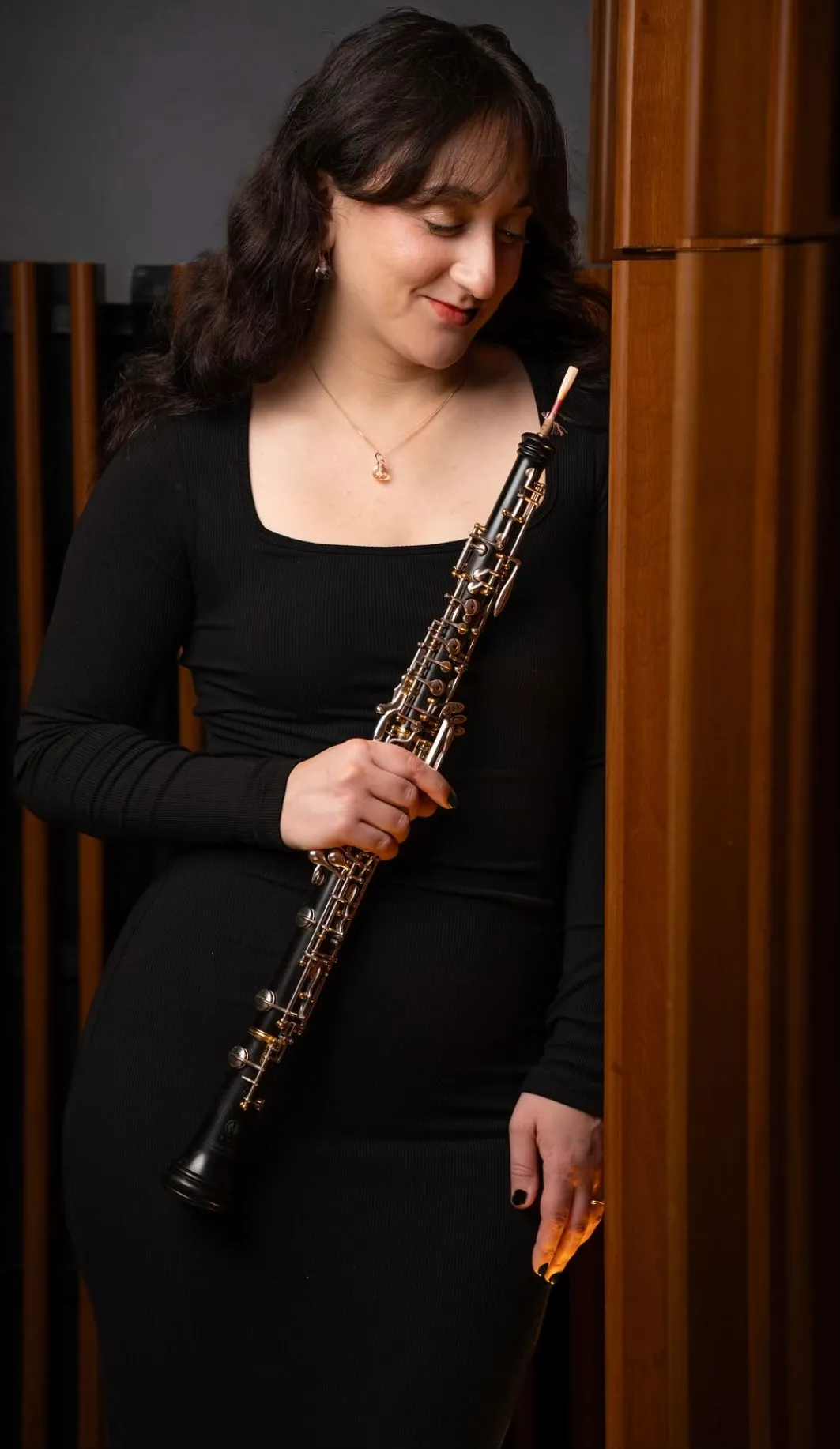 Alexis Porcaro in a black dress, holding her oboe